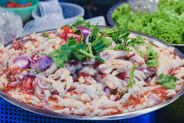 The chicken feet are mixed with a spicy and tangy dressing, which typically includes ingredients like lime juice, fish sauce, and chili flakes.