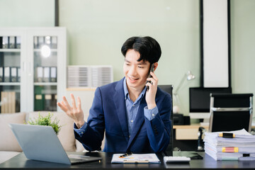 Young business man working at office with laptop, tablet and taking notes