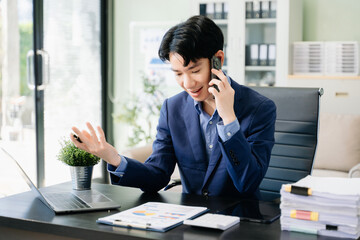 Young business man working at office with laptop, tablet and taking notes