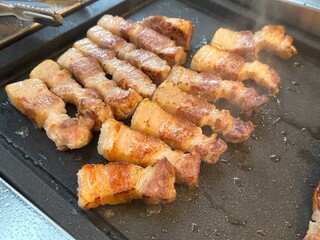 pork belly being grilled on pan