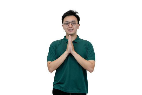 Smiling Young asian Man with Hands in Prayer Pose Against Plain Backdrop