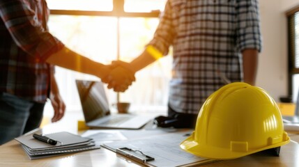 Construction handshake deal office sunlit blueprints