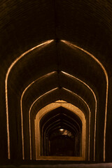 Obraz premium Stairs downward to the water reservoir in Yazd, Iran illuminated by ornamental lighting. 