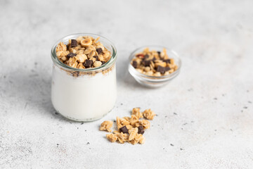 granola with chocolate, yogurt with granola in a glass jar