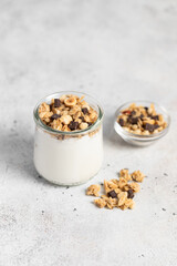 granola with chocolate, yogurt with granola in a glass jar