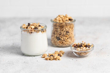 granola with chocolate, yogurt with granola in a glass jar