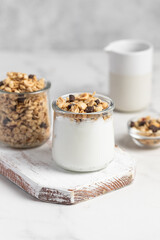granola with chocolate, yogurt with granola in a glass jar