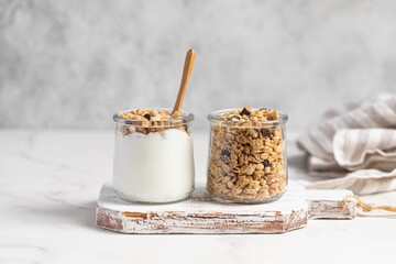 granola with chocolate, yogurt with granola in a glass jar