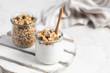 granola with chocolate, yogurt with granola in a glass jar