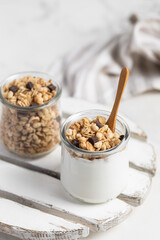 granola with chocolate, yogurt with granola in a glass jar