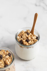 granola with chocolate, yogurt with granola in a glass jar