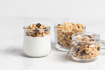 granola with chocolate, yogurt with granola in a glass jar