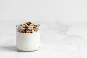 granola with chocolate, yogurt with granola in a glass jar
