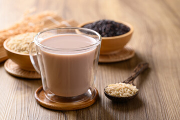 Organic rice milk in cup glass on wooden background, Alternative milk made from plant, non dairy