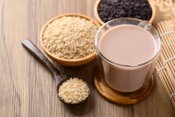 Organic rice milk in cup glass on wooden background, Alternative milk made from plant, non dairy