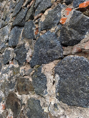 A close up of a stone wall with red and gray stones