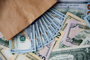 Big amount of US dollar bills in different nominations on table. Many dollar banknotes under natural light