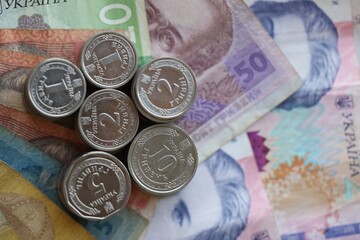 Few stacks of ukrainian money coins lies on old hryvnia banknotes