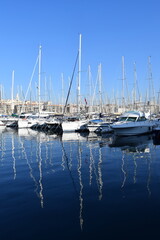 Obraz premium Boats docked in the Vieux-Port of Marseille, reflecting warm hues over the calm water. A picturesque scene showcasing the city's maritime charm.