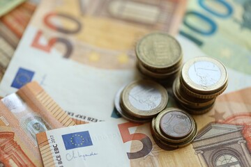 Stacks of euro cent coins lien on big amount of euro banknotes