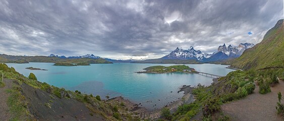 Fototapeta premium Iconic view of Torres del Paine mountains with Lake Pehoe and a small lodge in the foreground