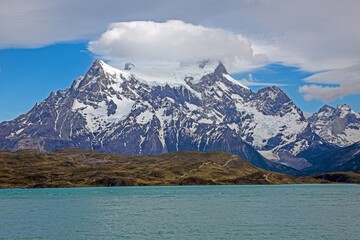 Panoramic view of Lake Pehoe with reflections of dramatic mountains and expansive skies in Torres del Paine