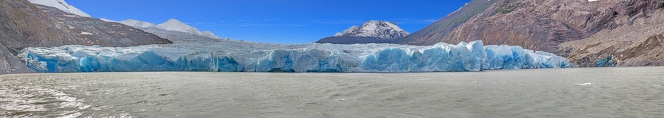 Distant view of Grey Glacier flowing into Lago Grey surrounded by mountains in Torres del Paine