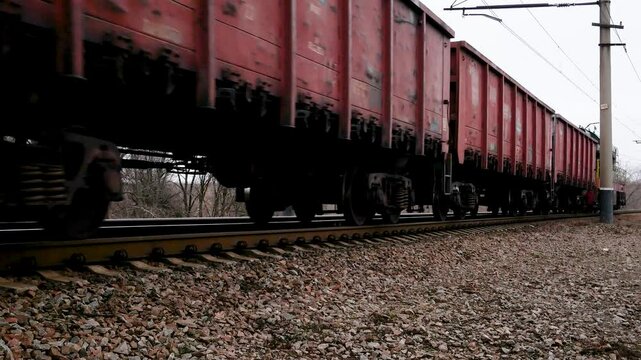 The train with freight cars travels by rail. Many wagons go into the distance, a long shot. Concept of freight transportation by rail.