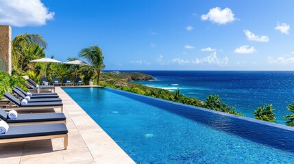 Fototapeta premium A luxurious infinity pool overlooking the ocean, featuring sleek lounge chairs, tropical greenery, and sparkling blue water under the midday sun. Ample space for summer banner text