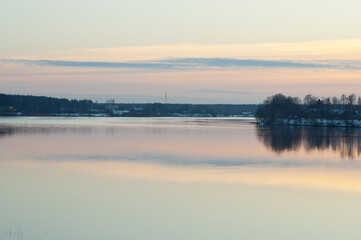 The photo shows a sunset on the river in winter