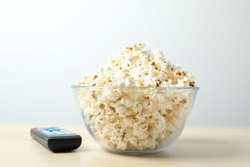 Delicious popcorn in a bowl on a colored background