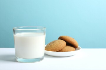 Glass of milk with cookies on table