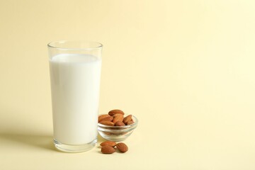 Glass of almond milk on color background