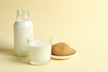 Glass and bottle of milk with cookies on table