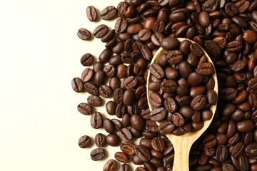 Spoon with coffee beans on color background 