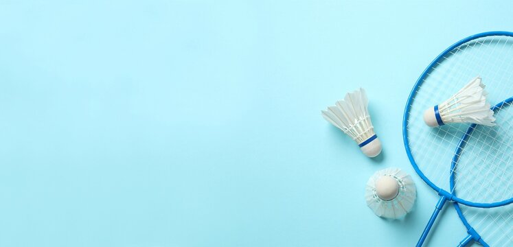 Badminton rackets and white badminton shuttlecocks on color background 