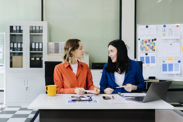 Diverse designer collaborate on project analysis with financial graphs. Strategic teamwork and insights drive company growth and success.