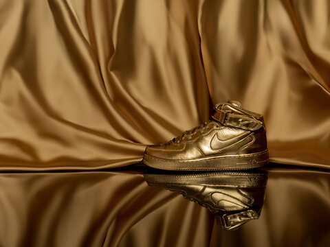 Custom golden Nike Air Force One Mid shoes studio shot