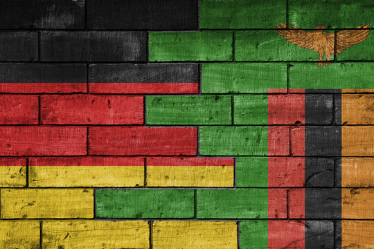 colourful painted big flag of germany and flag of zambia on a massive old brick wall background. concept