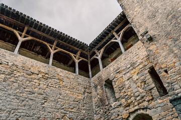 Low angle view of the interior stone walls and wooden beams of the porches and interior courtyards...