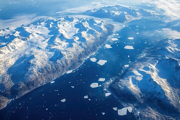 Fototapeta premium Majestic aerial view of icy mountains and glistening waters in a remote Arctic landscape