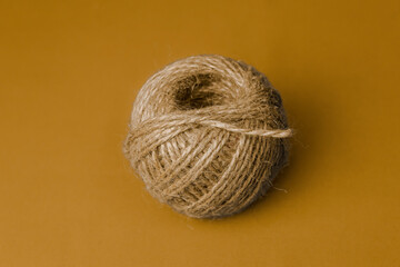 Ball of natural twine on a beige background