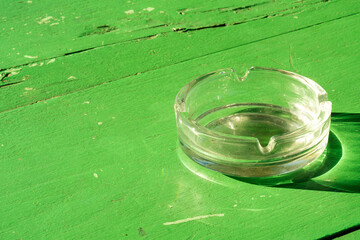 Empty Glass Cigarette Tray on Green Table