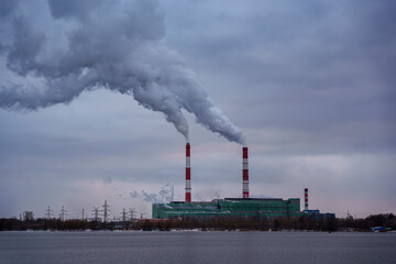 Industrial power plant with smoking chimneys on a winter day