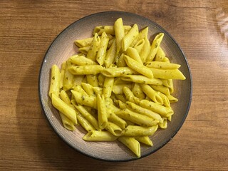 Penne Pasta With Creamy Sauce And Herbs Served On A White Plate
