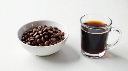 Fototapeta premium Aromatic Coffee Beans and a Dark Brew in a Clear Mug on a White Surface
