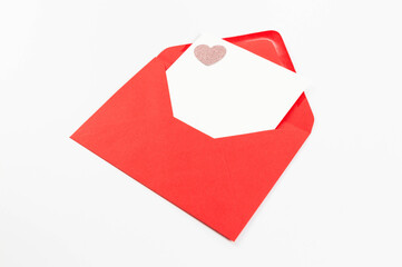 Top view of red envelope, white card on white background. Valentine's day, pink glitter heart,...