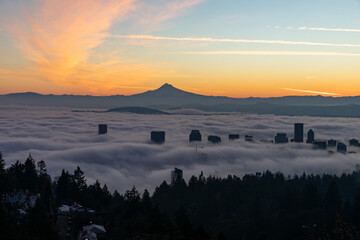 Breathtaking sunrise view of Downtown Portland blanketed by a sea of clouds, with the majestic Mount Hood in the background, creating a serene and picturesque Pacific Northwest landscape