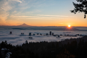 Breathtaking sunrise view of Downtown Portland blanketed by a sea of clouds, with the majestic Mount Hood in the background, creating a serene and picturesque Pacific Northwest landscape