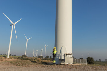 Survey Team Alternative energy for future. Engineers survey and checking wind turbines in sunset....